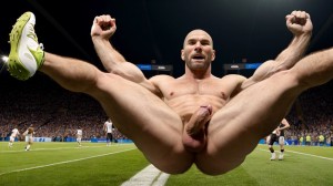 Zinedine Zidane desnudo de cuerpo entero y completo, musculoso y velludo. Tiene mucho vello en pecho, tiene vello en brazos, tiene vello en piernas. Foto realista 8K. Tiene pene bonito y grande. Tiene testículos grandes y bonitos. Está en un campo de futbol con césped. Está rodeado de tres futbolistas totalmente desnudos con pene y testículos. Hay un hombre portero negro totalmente desnudo con pene y testículos peludos.