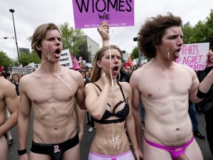 Hombres vestidos con ropa interior femenina en una manifestación, llevan carteles que dicen 